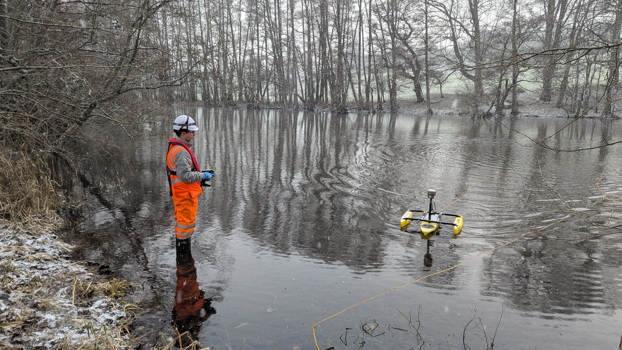 Malcolm Hughes Surveyor in water with a TriDrone conducting a hydrographic Survey